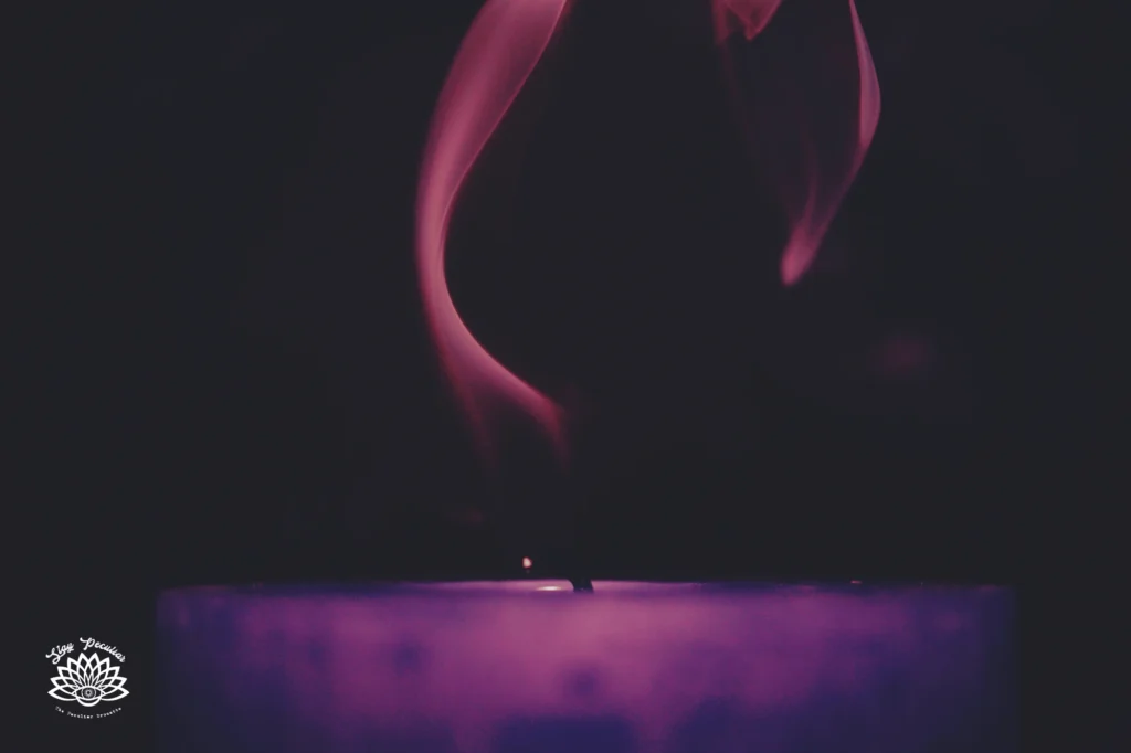 What Does a Purple Candle Mean: image of a dark purple candle, with purple smoke against a black background.